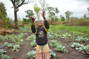 Eight-year-old Justine loves eating the fresh vegetables being grown in a community garden near her home. A total of 350 families in Justine’s village received seeds to grow fresh vegetables to feed their families and sell extra at the market for income. ©2018 World Vision/Mark Nonkes