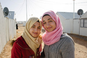 Nour, 14 (red coat) and her older sister Ghina, 16, both from Damascus, Syria. © 2017 World Vision, Oliver Missen.