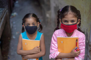 two young girls wearing masks in India