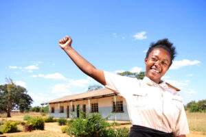 Girl in Zambia raises her arm showing strength